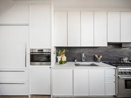 a kitchen with white cabinets and white appliances