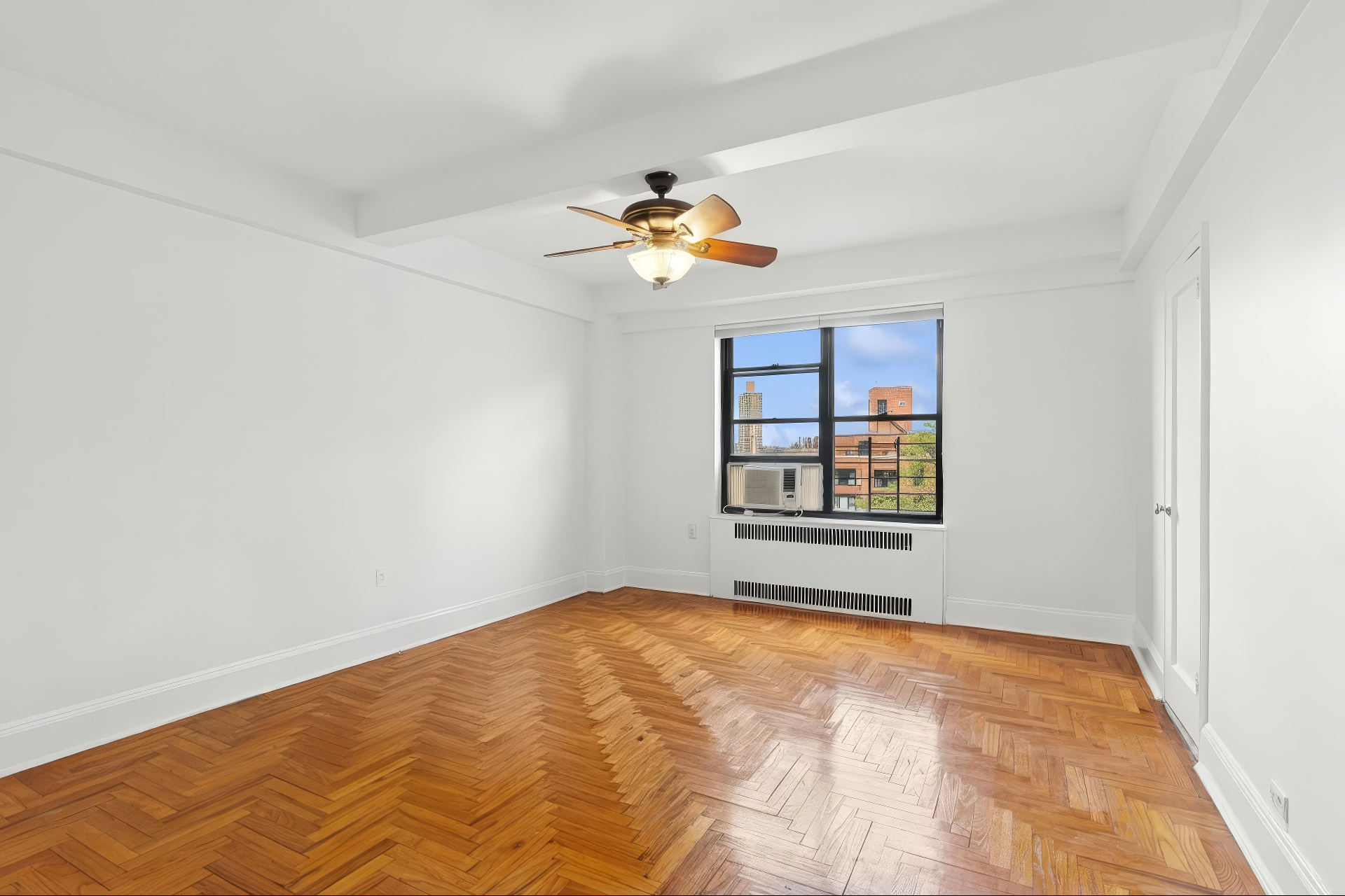 55 Park Terrace East, Unit B74 Manhattan, NY 10034 - Photo 12 of 26 a view of a big room with windows and chandelier fan