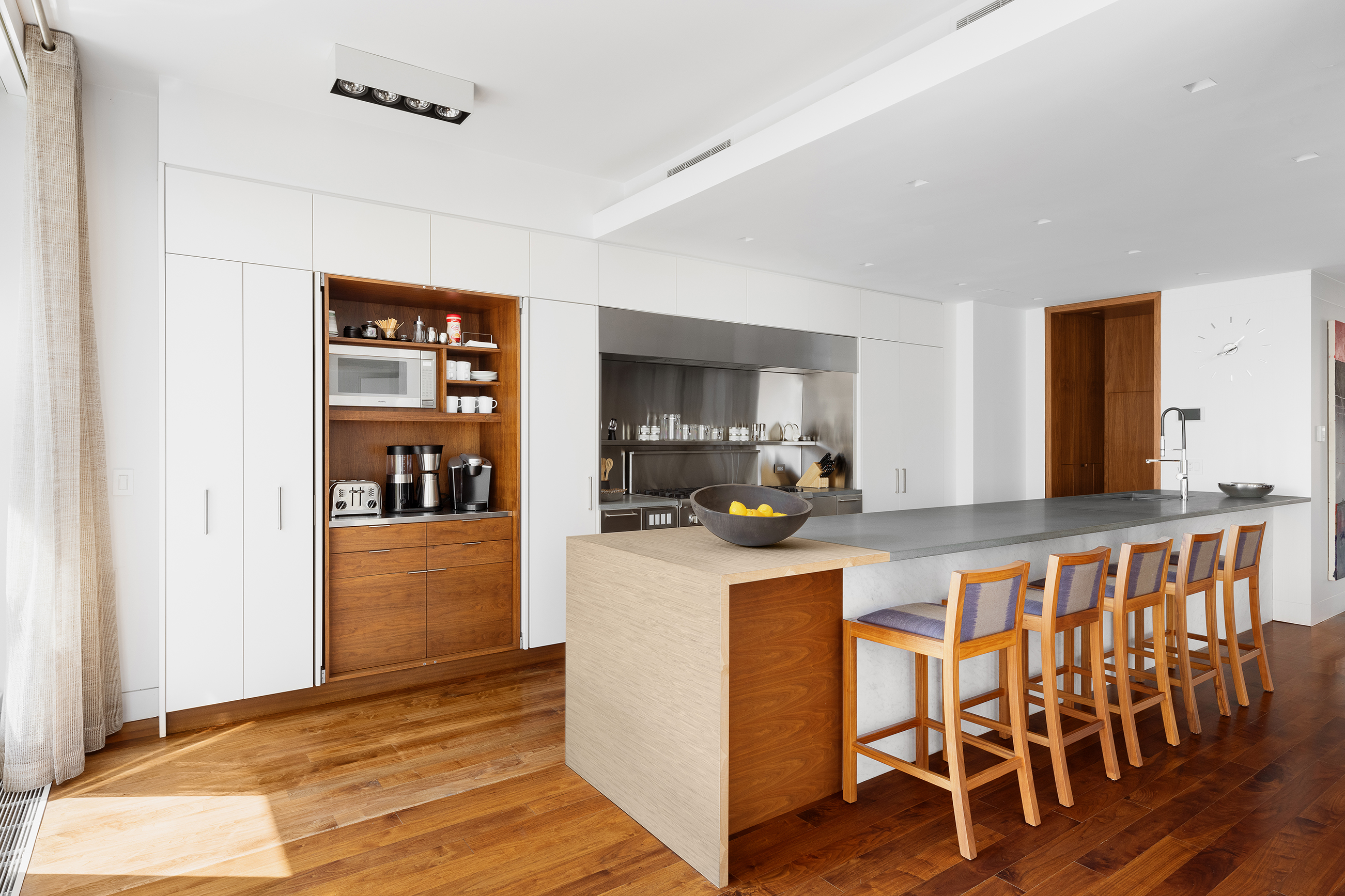 57 Irving Place, Unit PH9/10 Manhattan, NY 10003 - Photo 7 of 33 a kitchen with stainless steel appliances a dining table chairs and wooden floor