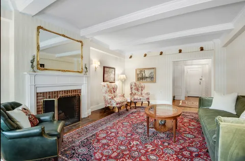 a living room with furniture a rug and a fireplace