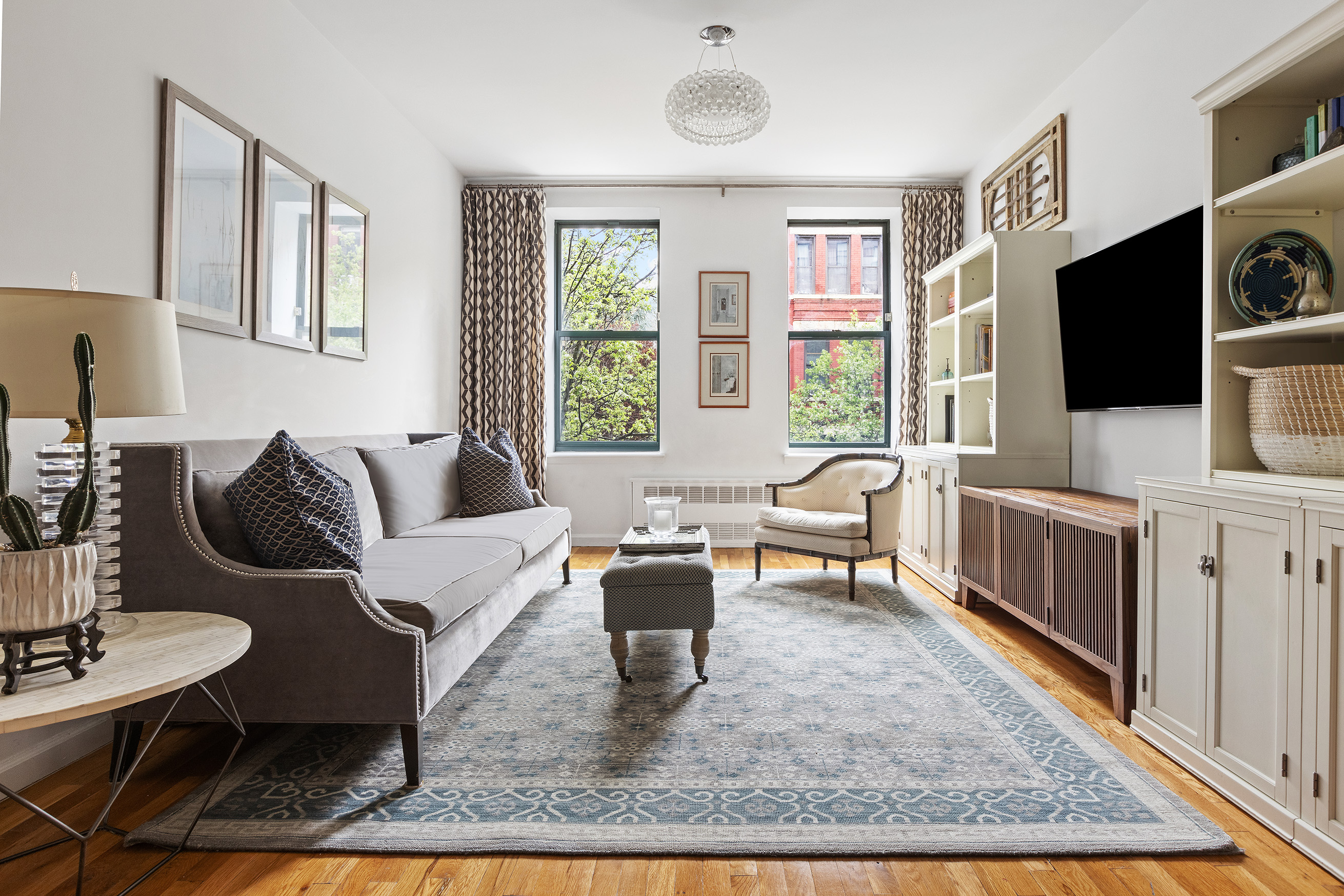 364 West 117th Street, Unit 2C Manhattan, NY 10026 - Photo 1 of 11 a living room with furniture a flat screen tv and a rug