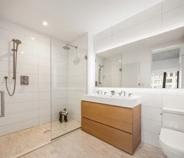 a bathroom with a sink mirror and shower