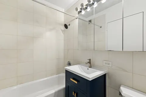 a bathroom with a sink toilet vanity and shower