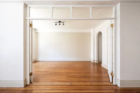 a view of a closet with wooden floor