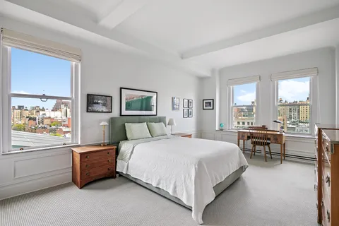 a bedroom with a bed and a large window