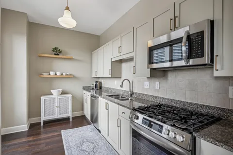a kitchen with stainless steel appliances granite countertop a sink stove and cabinets