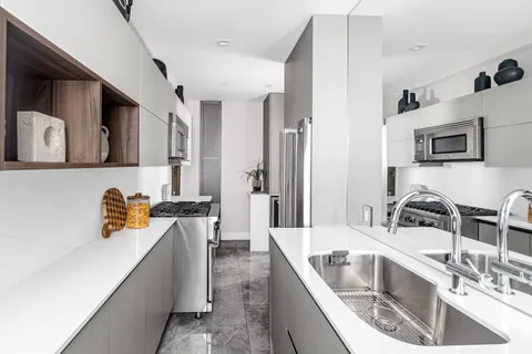 a kitchen with stainless steel appliances granite countertop a sink a stove and a refrigerator