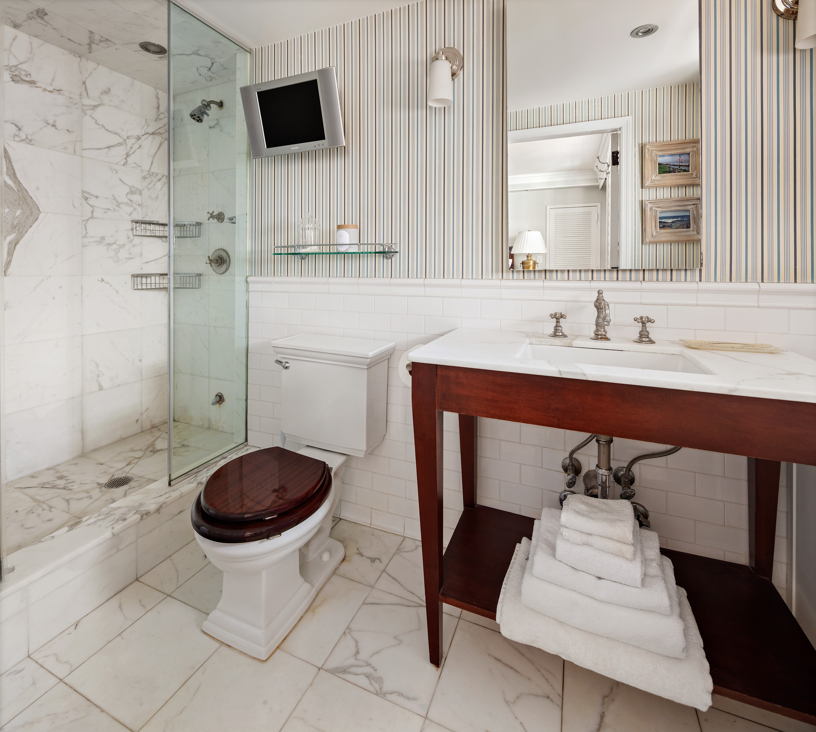 135 East 83rd Street, Unit 14D Manhattan, NY 10028 - Photo 5 of 8 a bathroom with a sink a toilet and a mirror