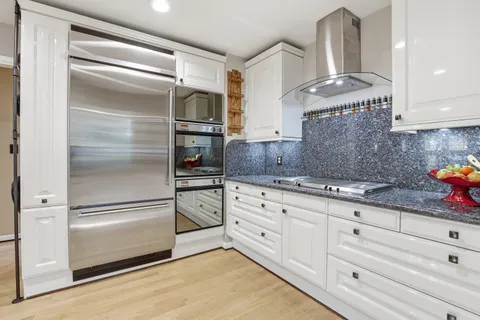 a large kitchen with a counter space a sink and refrigerator