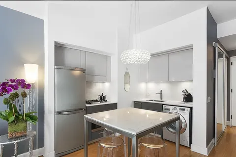 a kitchen with a sink a refrigerator and cabinets
