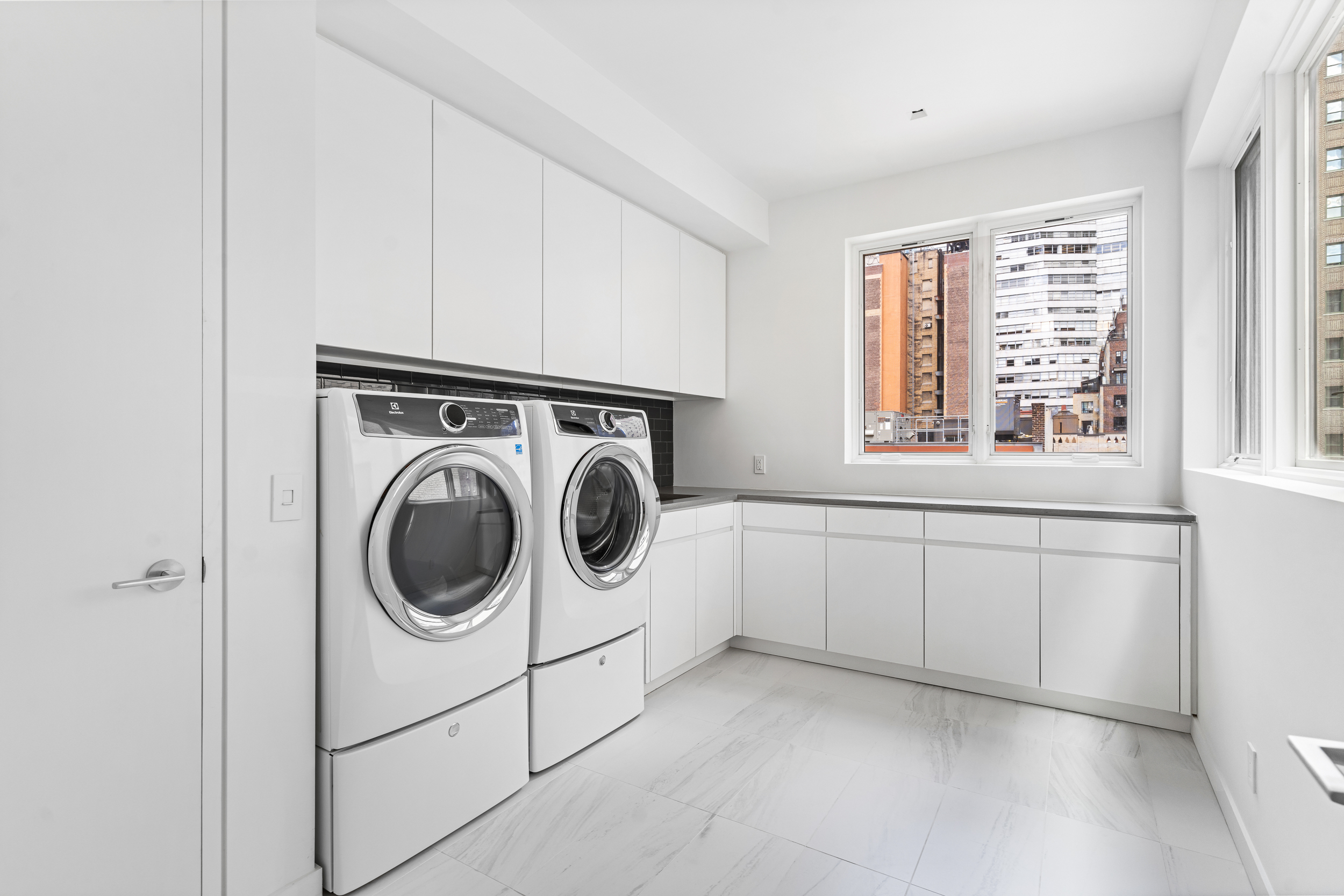 135 East 38th Street Manhattan, NY 10016 - Photo 31 of 32 a utility room with dryer and washer