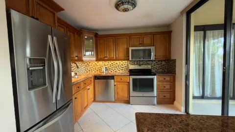 a kitchen with granite countertop a refrigerator stove and sink
