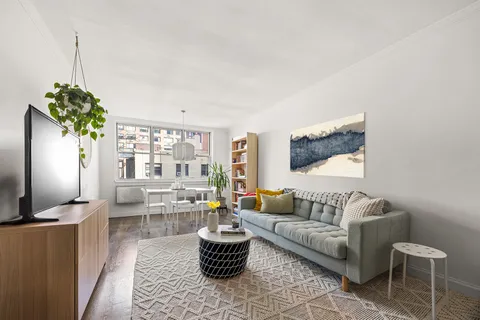 a living room with furniture a chandelier and a flat screen tv