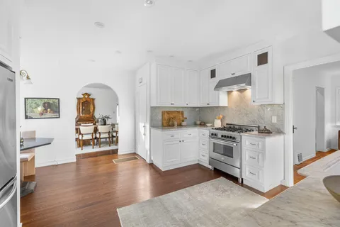 a kitchen with granite countertop a sink stove and cabinets