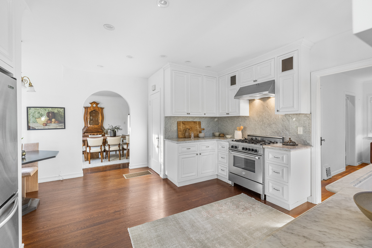926 Burnside Avenue Los Angeles, CA 90036 - Photo 18 of 71 a kitchen with stainless steel appliances granite countertop a stove top oven a sink a refrigerator and white cabinets with wooden floor