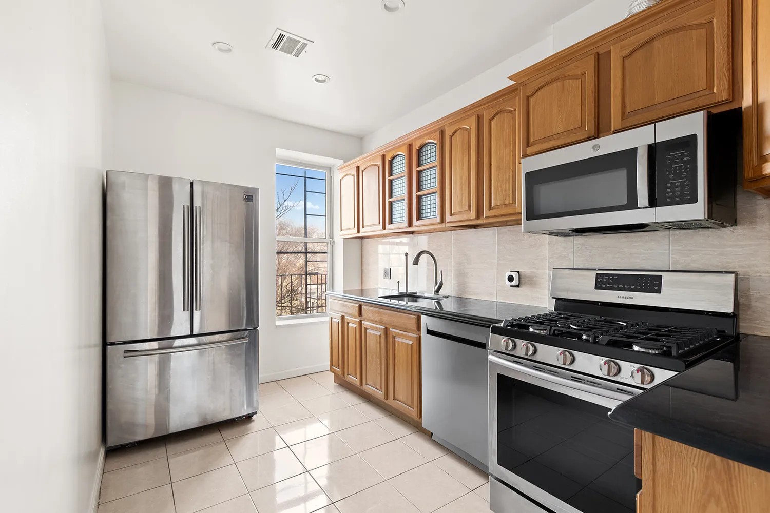 a kitchen with stainless steel appliances granite countertop a stove microwave and refrigerator