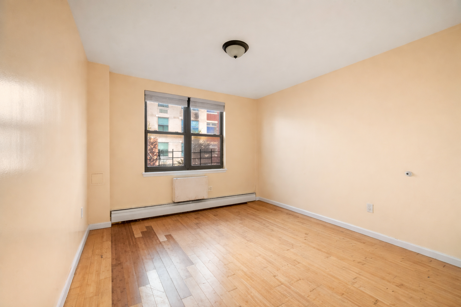 415 East 160th Street, Unit 3 Bronx, NY 10451 - Photo 4 of 10 an empty room with wooden floor and windows