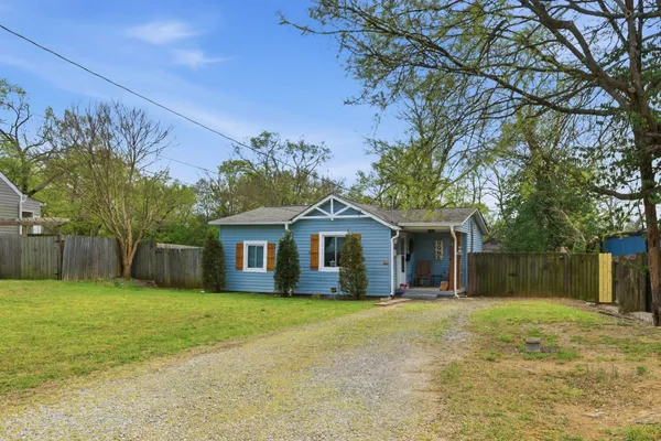 a front view of house with yard and trees in the background