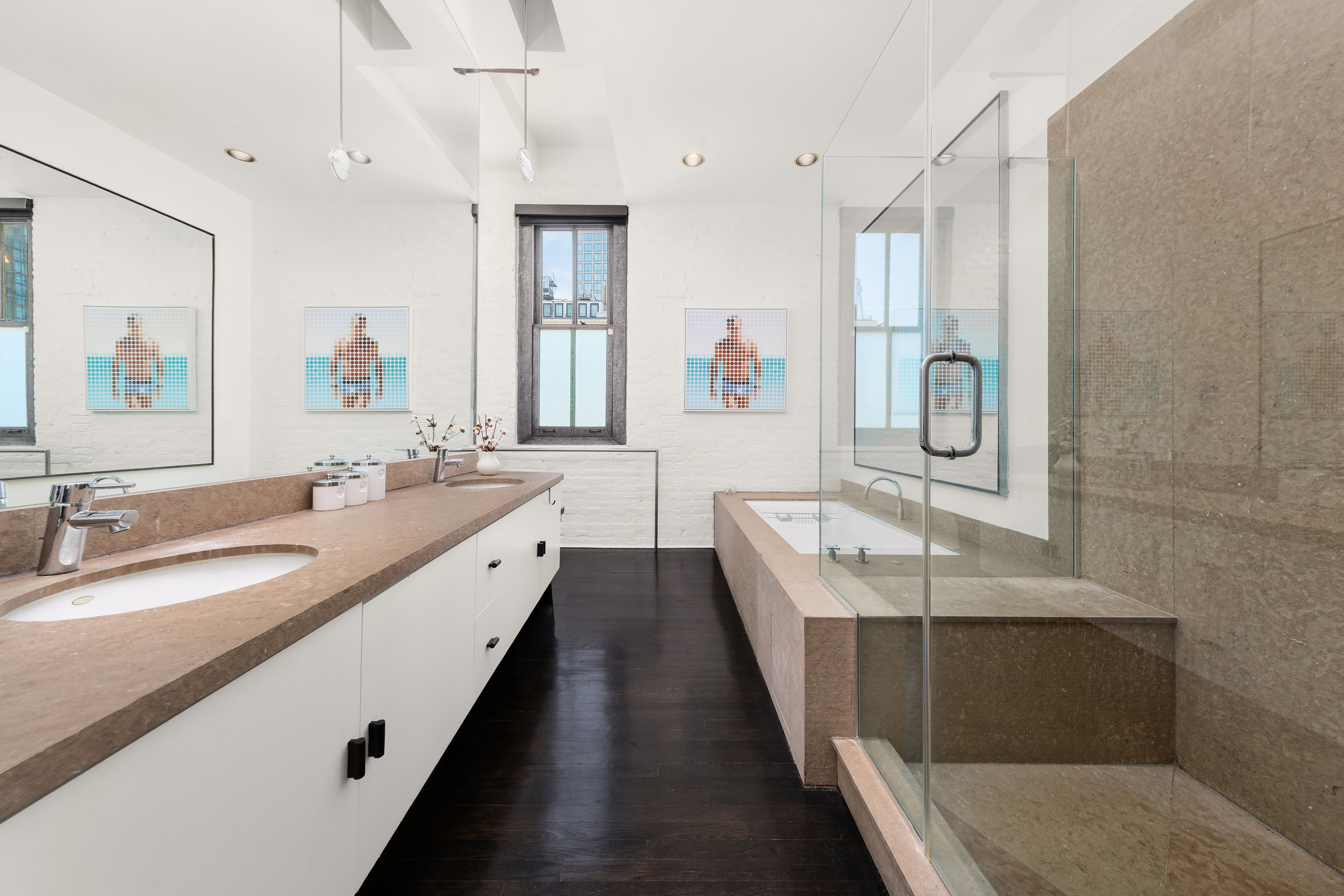 448 West 37th Street, Unit 11G/12G Manhattan, NY 10018 - Photo 12 of 17 a spacious bathroom with double vanity sinks a large mirror and a shower