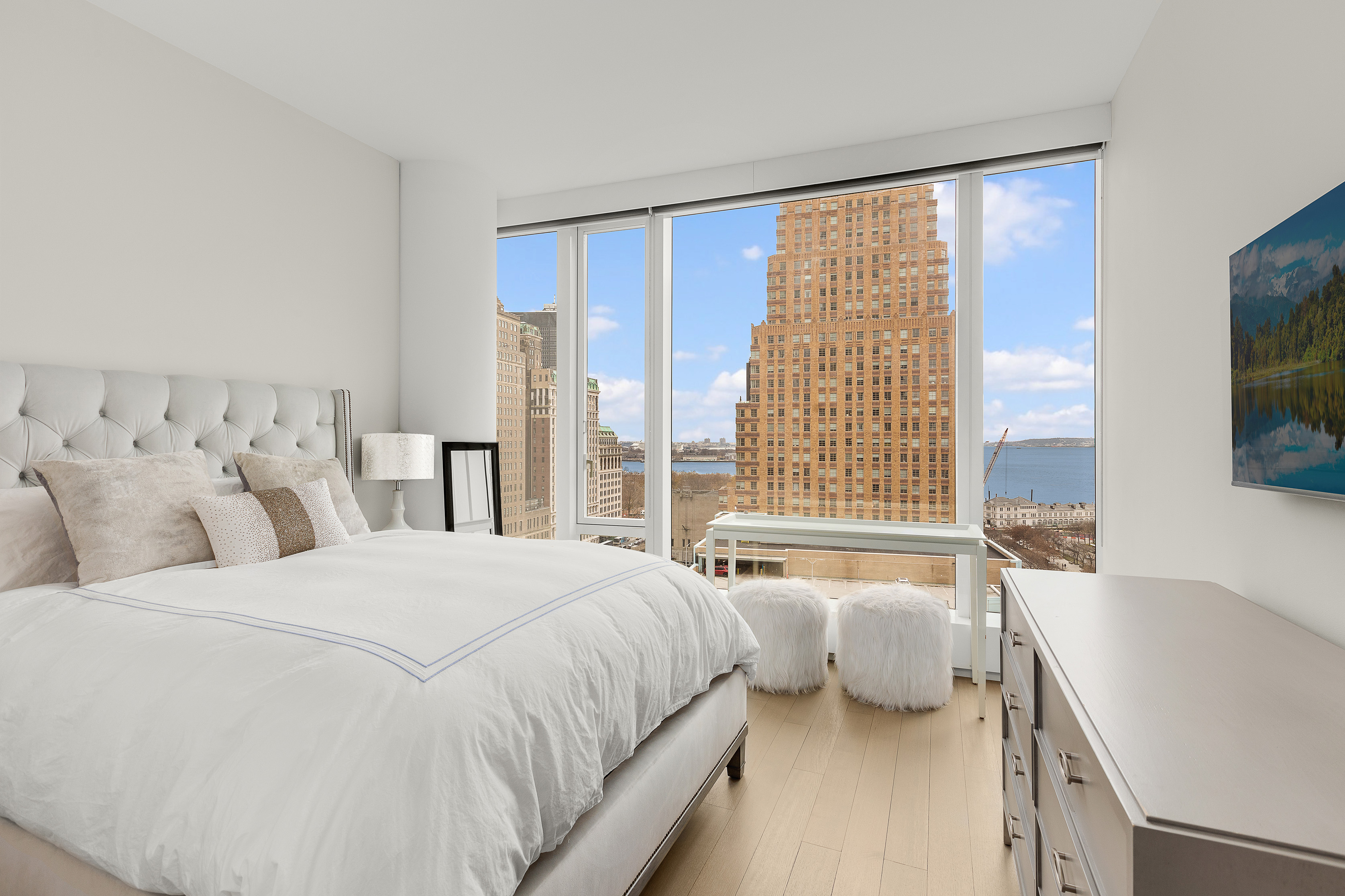 50 West Street, Unit 14B Manhattan, NY 10006 - Photo 11 of 29 a spacious bedroom with a large bed and a large window