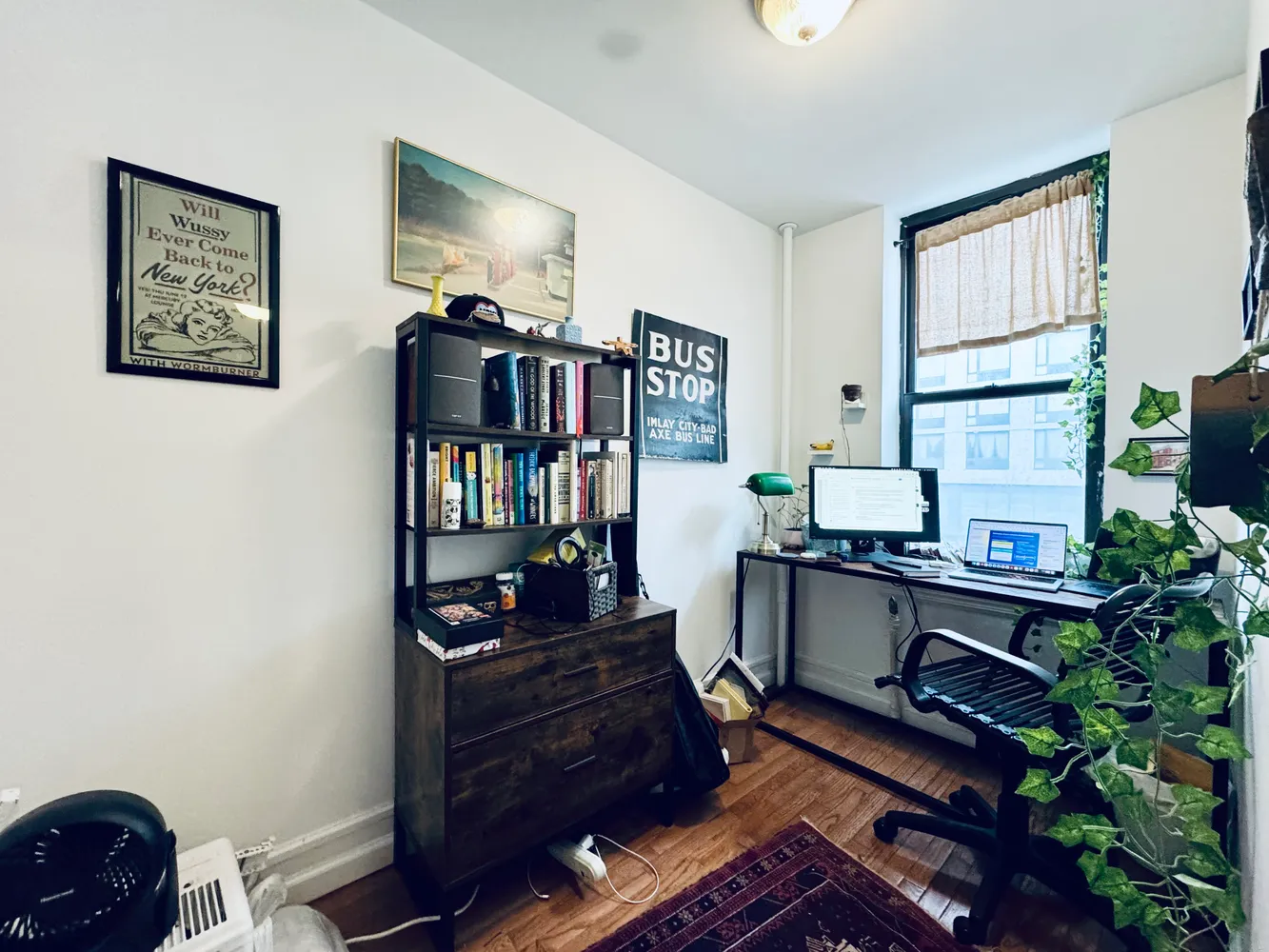 a living room with furniture a bookshelf and a window