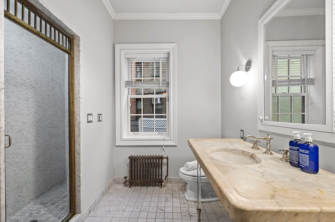 58 Downing Street Manhattan, NY 10014 - Photo 12 of 21 a bathroom with a granite countertop sink and a mirror