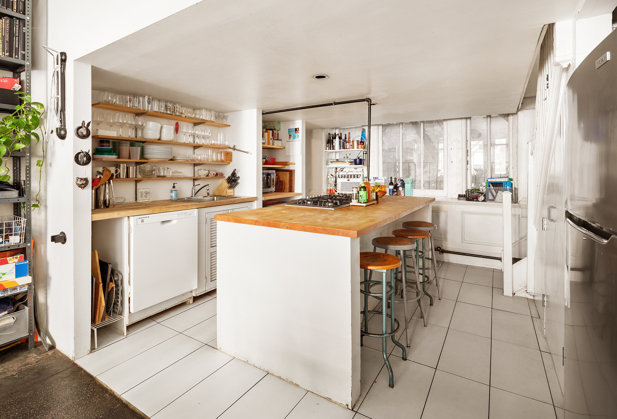 90 West Broadway, Unit 2B Manhattan, NY 10007 - Photo 4 of 12 a kitchen with a sink a stove and a refrigerator