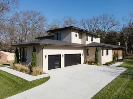 a front view of a house with yard and trees