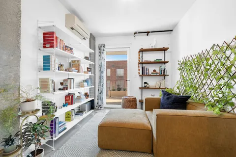 a living room with furniture and a book shelf