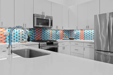 a kitchen with white cabinets sink and stainless steel appliances