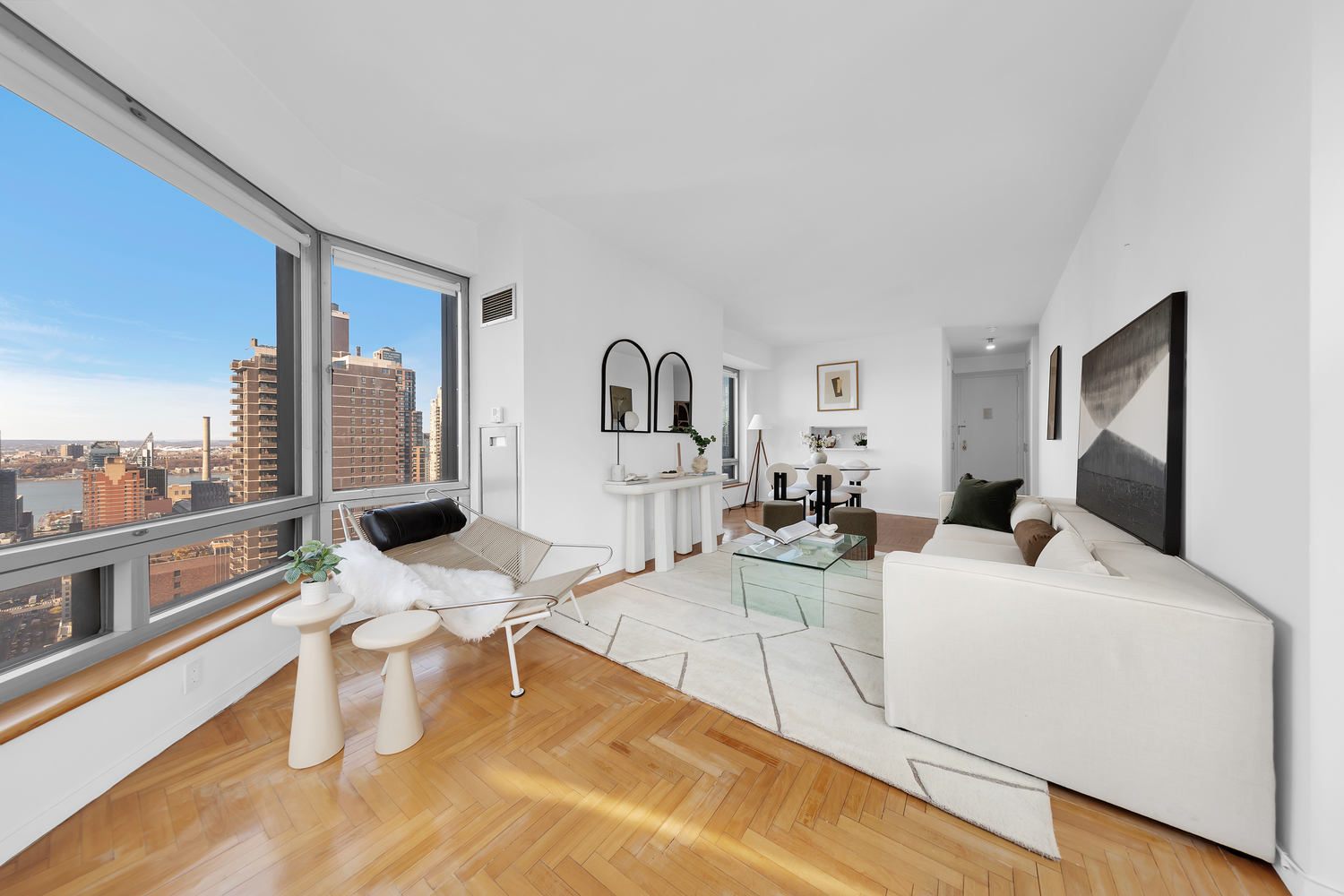 301 West 57th Street, Unit 33E Manhattan, NY 10019 - Photo 1 of 13 a living room with furniture a rug and white walls