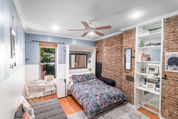 a bedroom with a bed wooden floor and window