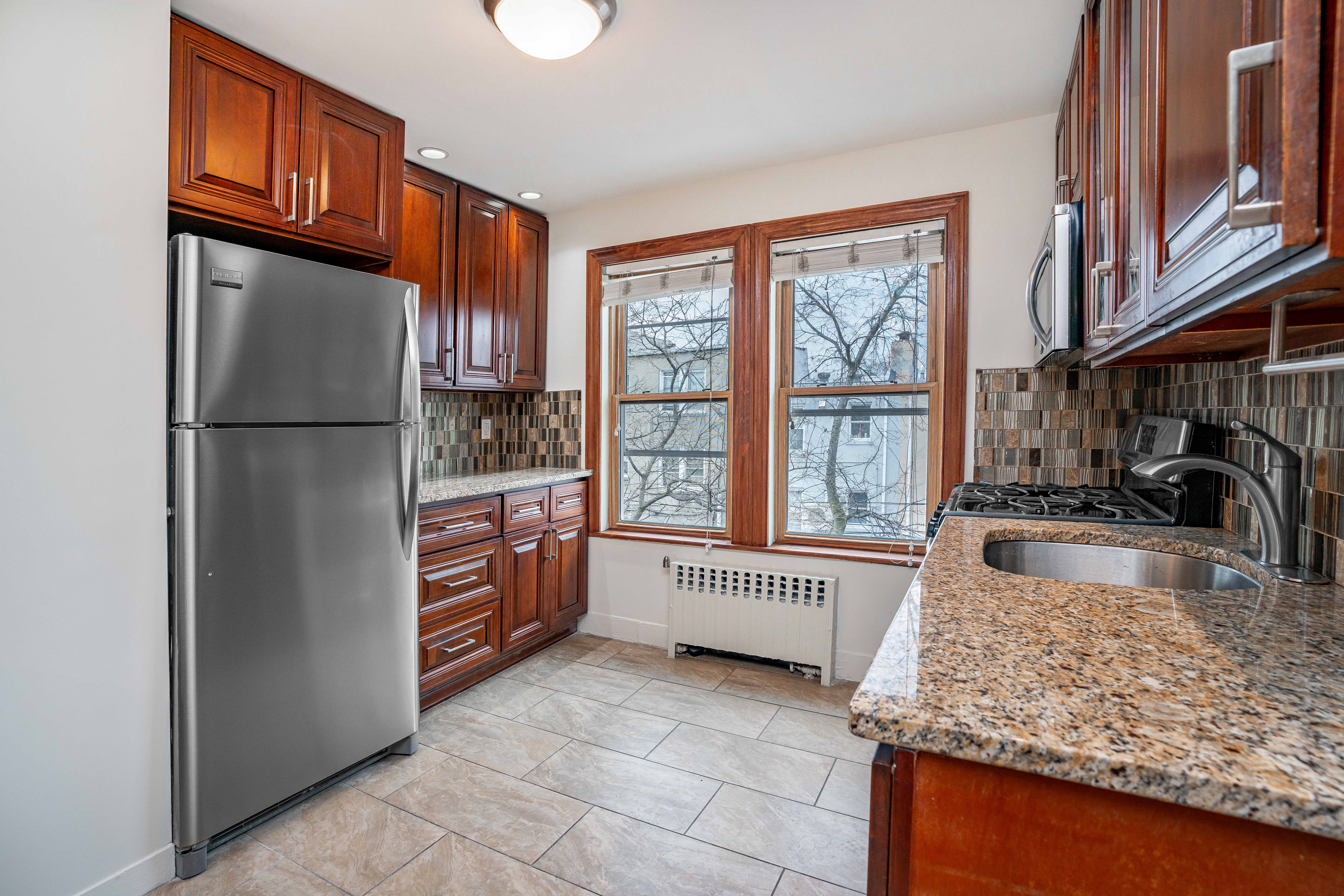 20-60 33rd Street, Unit 2 Queens, NY 11105 - Photo 4 of 10 a kitchen with refrigerator and cabinets