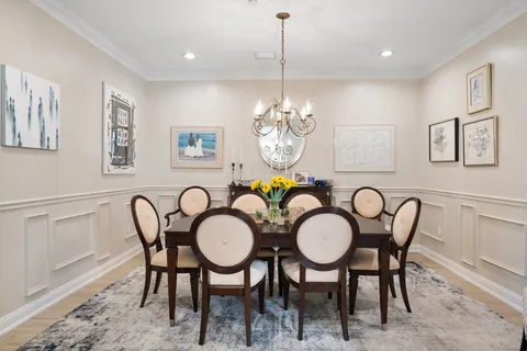 a view of a dining room with furniture a chandelier and wooden floor