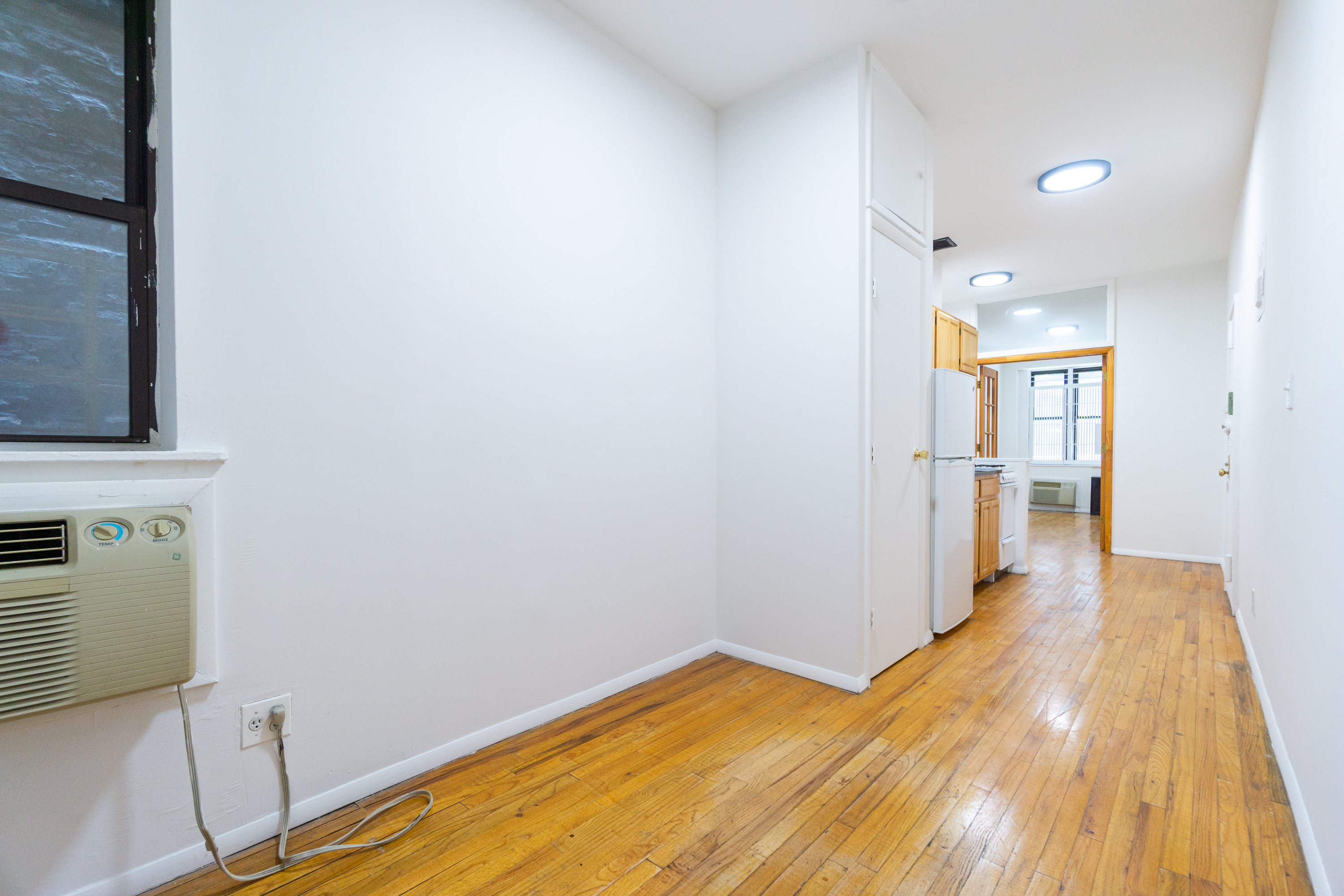 319 East 25th Street, Unit 1B Manhattan, NY 10010 - Photo 6 of 15 a view of a room with wooden floor and a bathroom
