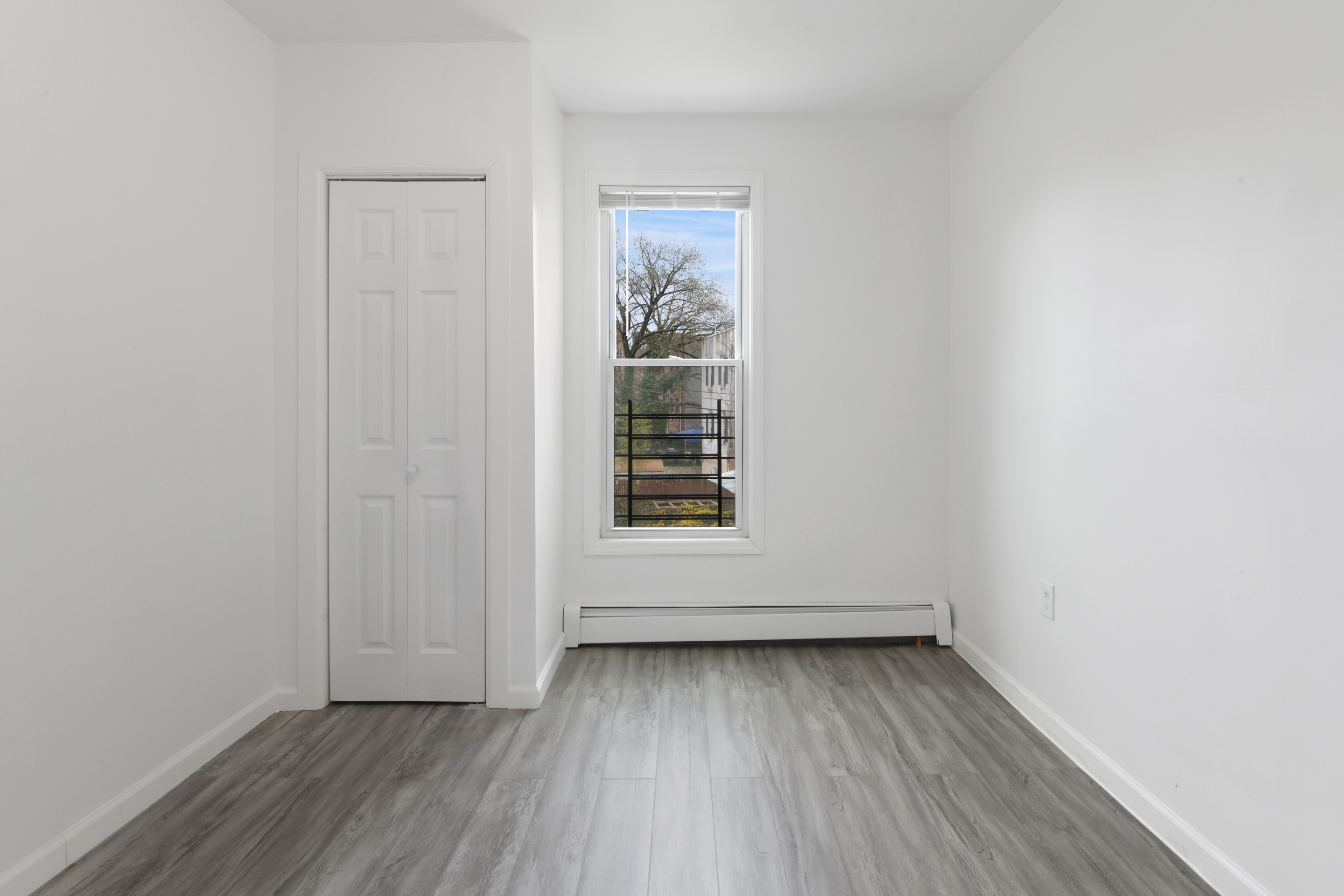 332 East 198th Street, Unit 2 Bronx, NY 10458 - Photo 4 of 10 an empty room with wooden floor and windows