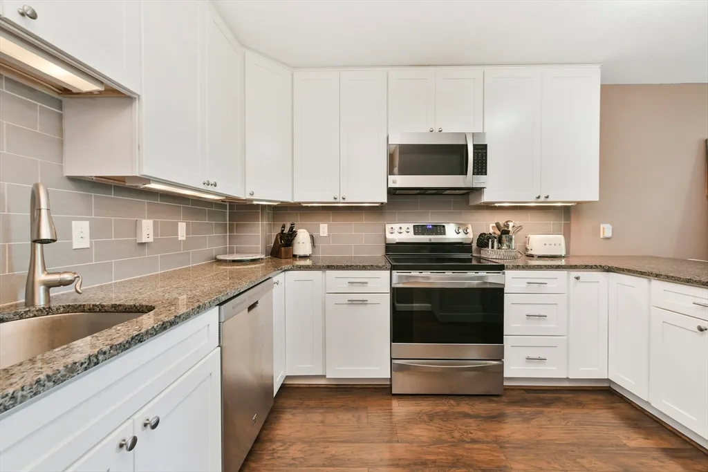 a kitchen with stainless steel appliances granite countertop a sink and a stove