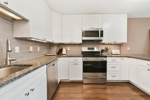 a kitchen with stainless steel appliances granite countertop a sink and a stove