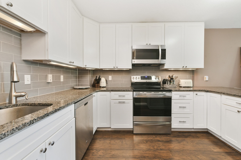 164 Galen Street, Unit 52 Watertown, MA 02472 - Photo 2 of 20 a kitchen with stainless steel appliances granite countertop a sink and a stove