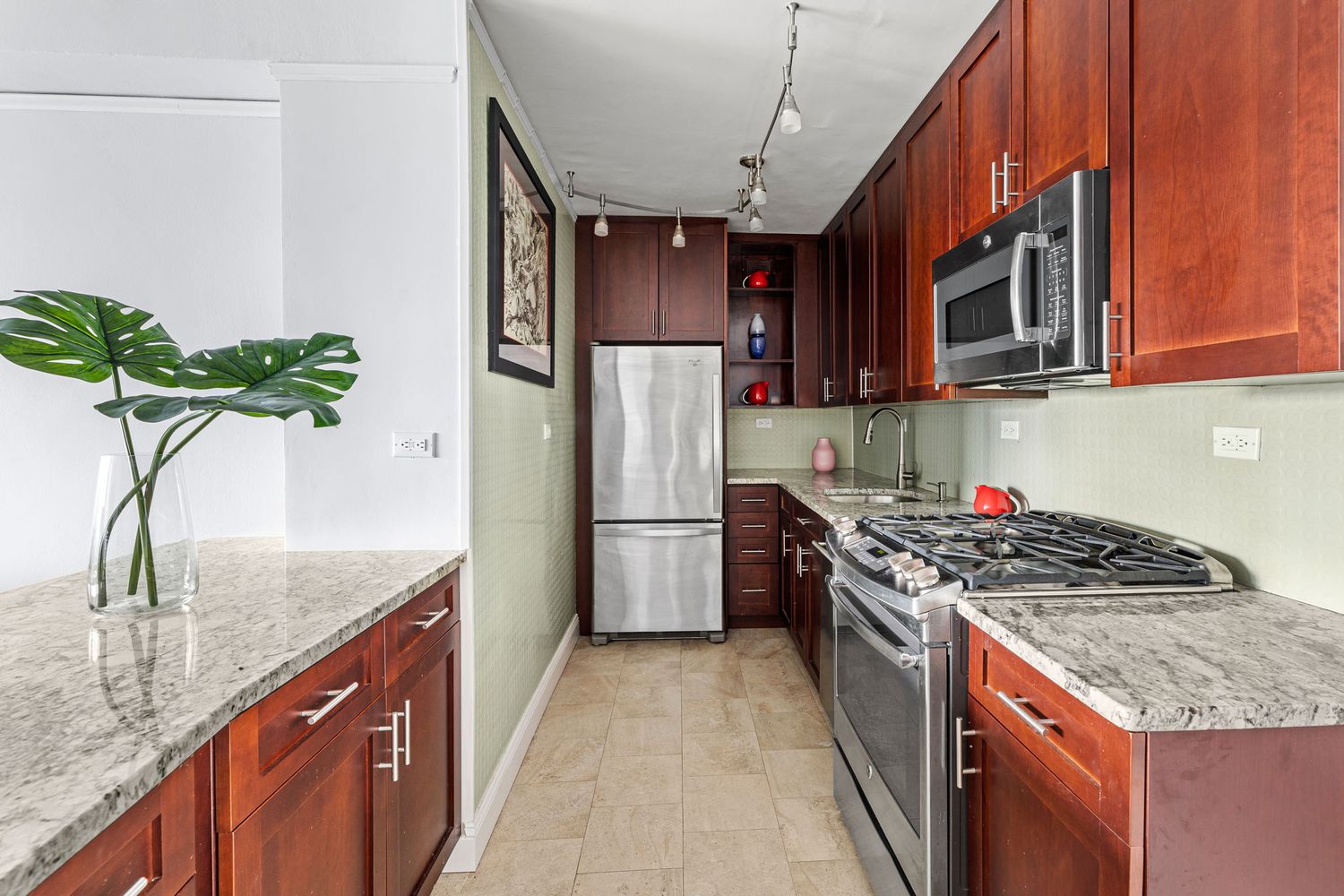900 West 190th Street, Unit 14E Manhattan, NY 10040 - Photo 6 of 9 a kitchen with stainless steel appliances granite countertop a refrigerator a stove and a sink