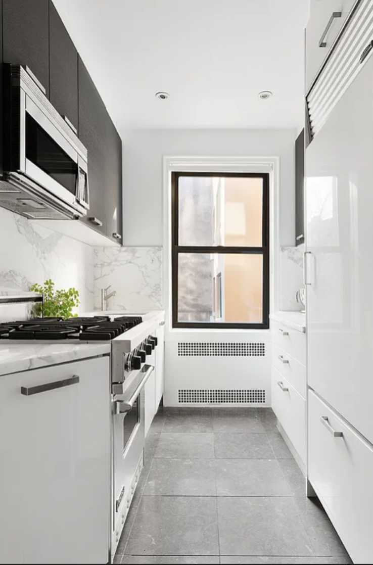 20 Clinton Street, Unit 4E Manhattan, NY 10002 - Photo 4 of 10 a kitchen with granite countertop white cabinets and white appliances