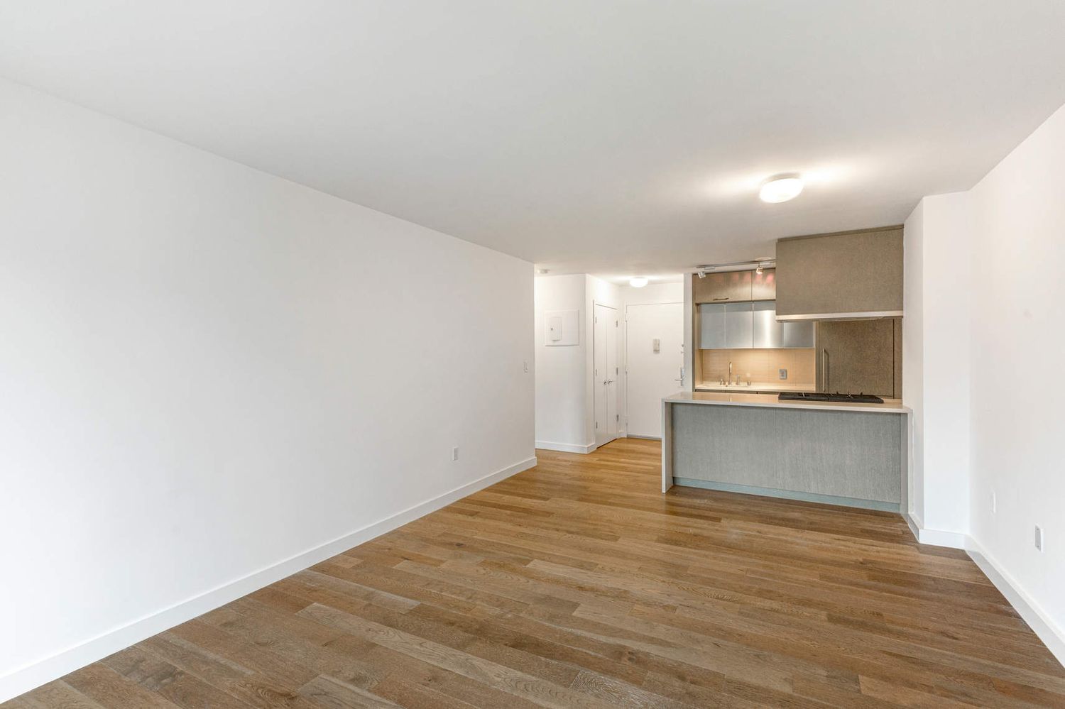 225 Rector Place, Unit 7M Manhattan, NY 10280 - Photo 4 of 13 a view of kitchen and empty room with wooden floor