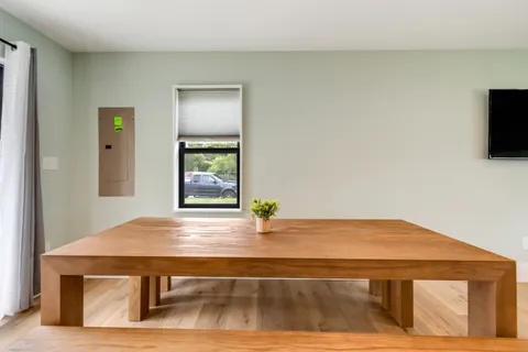a kitchen with stainless steel appliances granite countertop a refrigerator a stove top oven a sink dishwasher and white cabinets with wooden floor