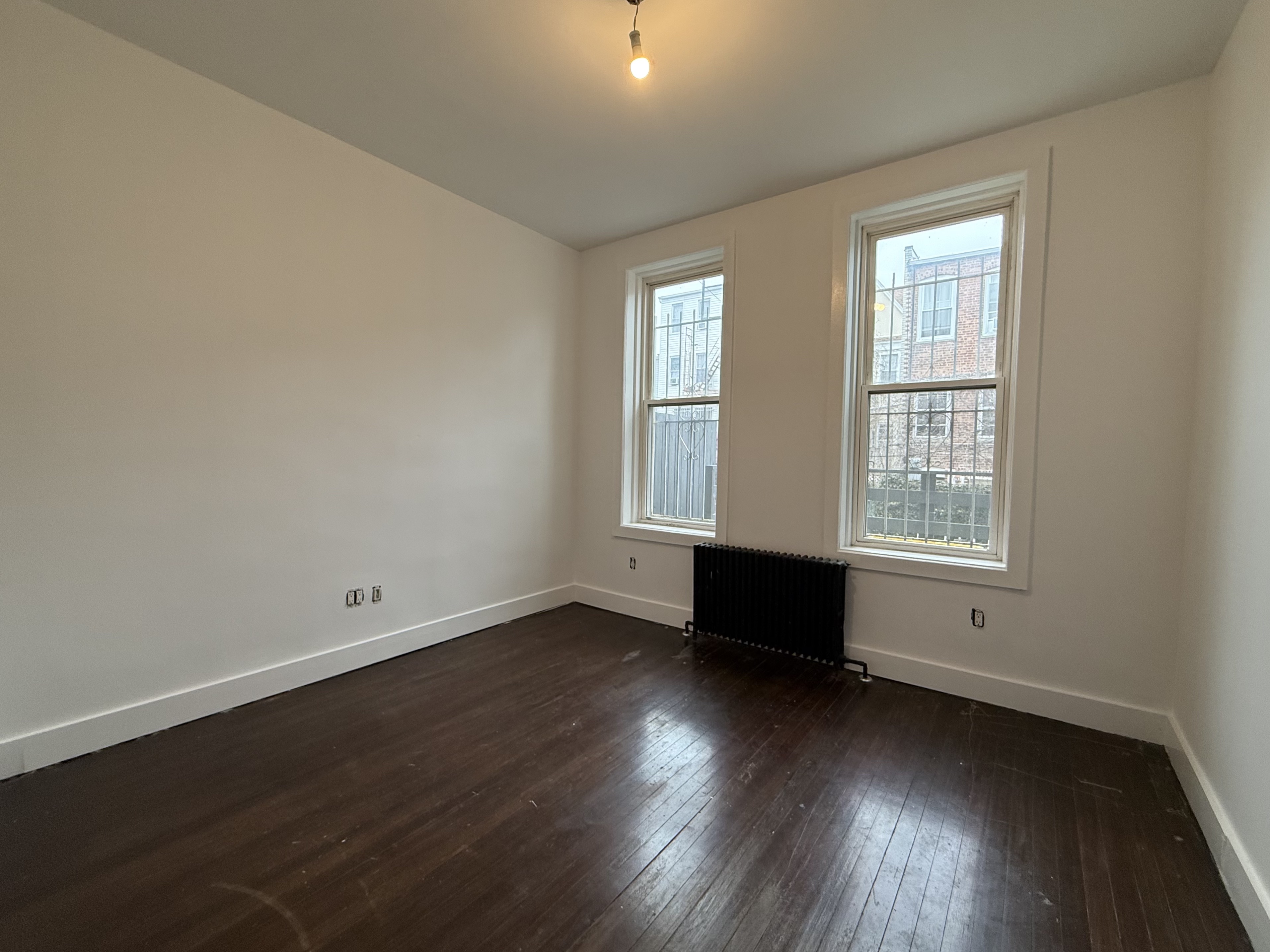 249 94th Street, Unit 1 Brooklyn, NY 11209 - Photo 5 of 13 an empty room with wooden floor and windows
