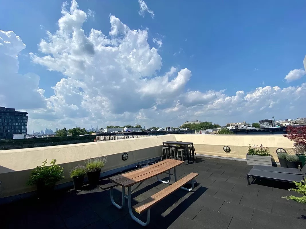 318 Knickerbocker Avenue, Unit 3D Brooklyn, NY 11237 - Photo 7 of 14 a view of a terrace with lawn chairs and wooden fence