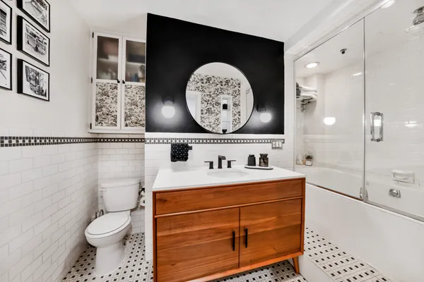 a bathroom with a toilet sink and mirror