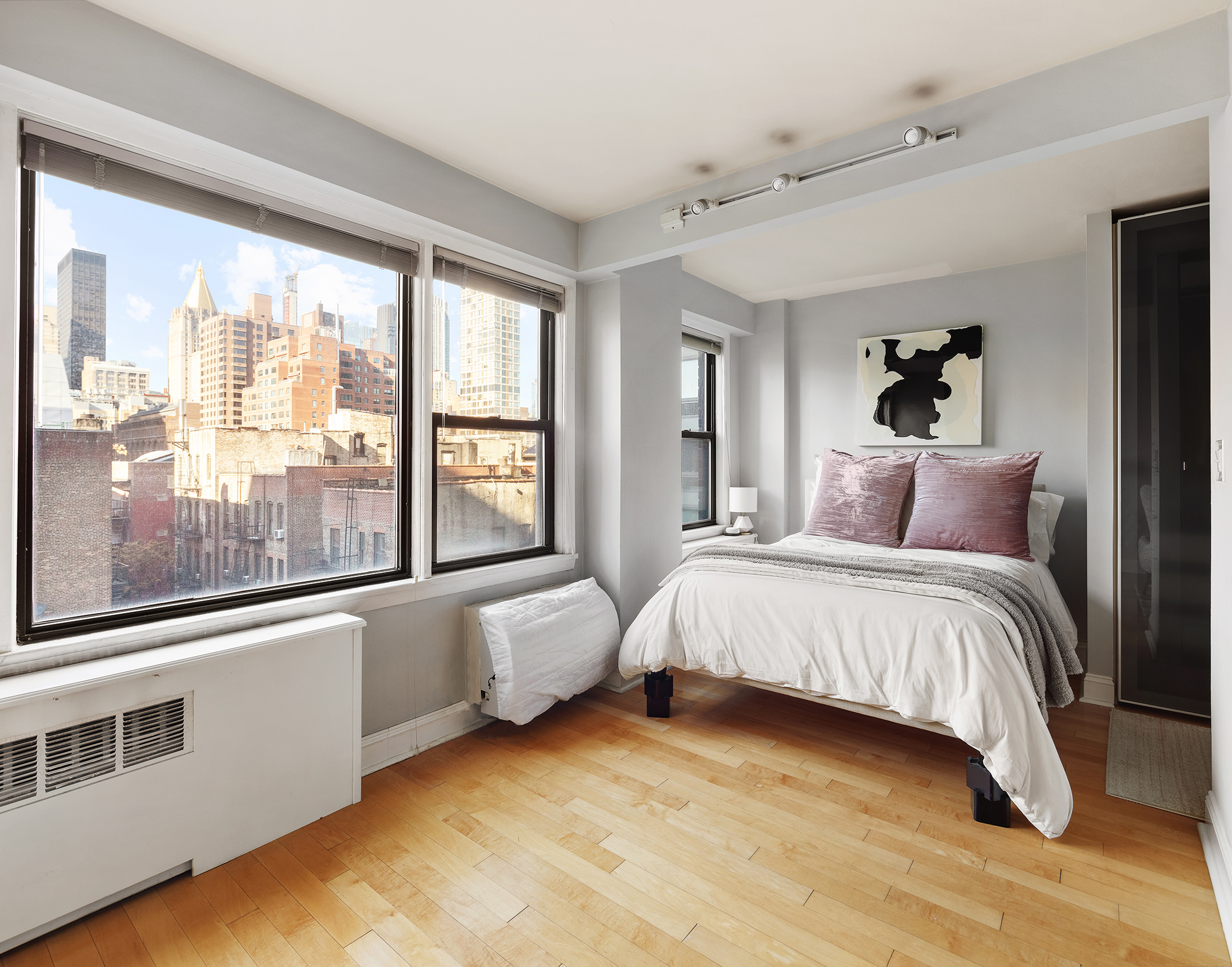245 East 24th Street, Unit 9B Manhattan, NY 10010 - Photo 4 of 6 a bedroom with a bed and large window
