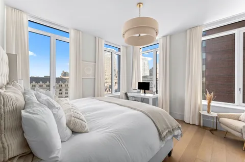 a spacious bedroom with a bed and a chandelier