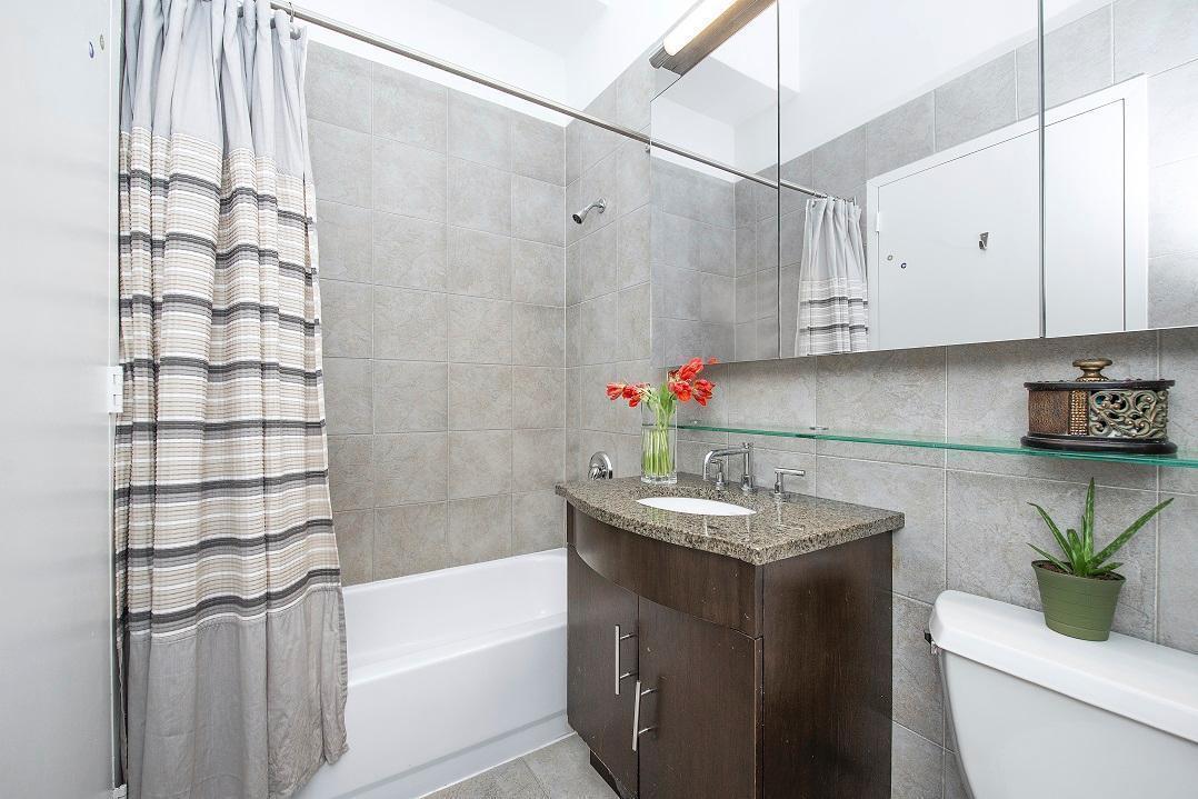 80 John Street, Unit 2F Manhattan, NY 10038 - Photo 5 of 7 a bathroom with a granite countertop sink a toilet and bathtub