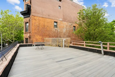 a view of a balcony with chairs and wooden floor